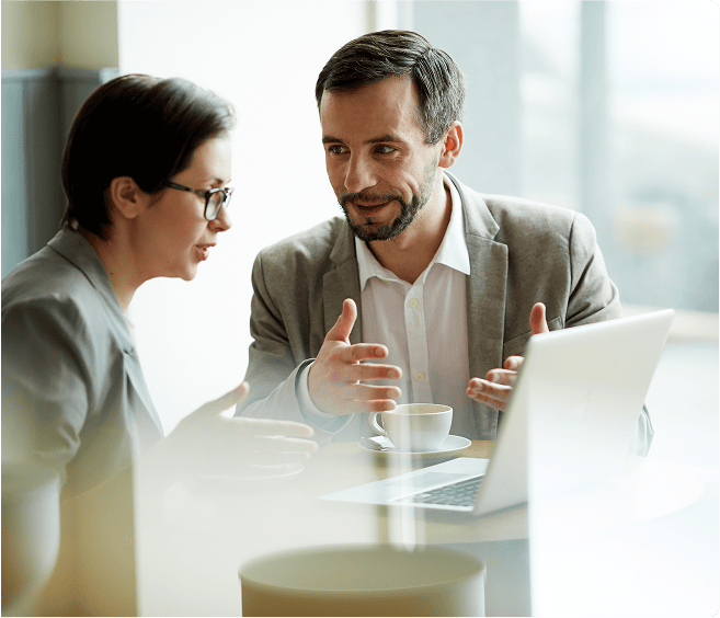 Erwachsene Geschäftspersonen im Gespräch bei einem Meeting, diskutieren vor einem Laptop, symbolisieren professionelle Zusammenarbeit, Business-Meeting, Beratung und Teamarbeit.